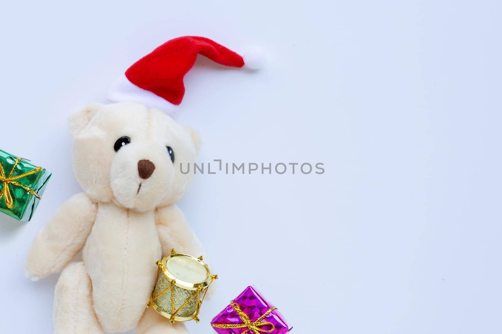 Toy bear wearing a santa hat on white background. Christmas holidays concept