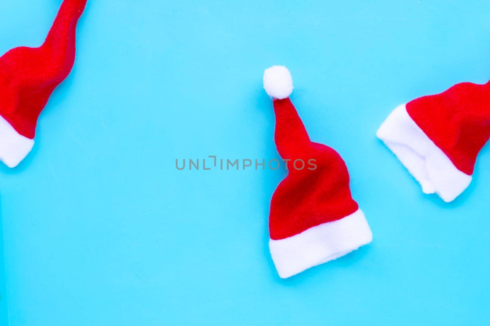 Santa hats on blue background. Copy space
