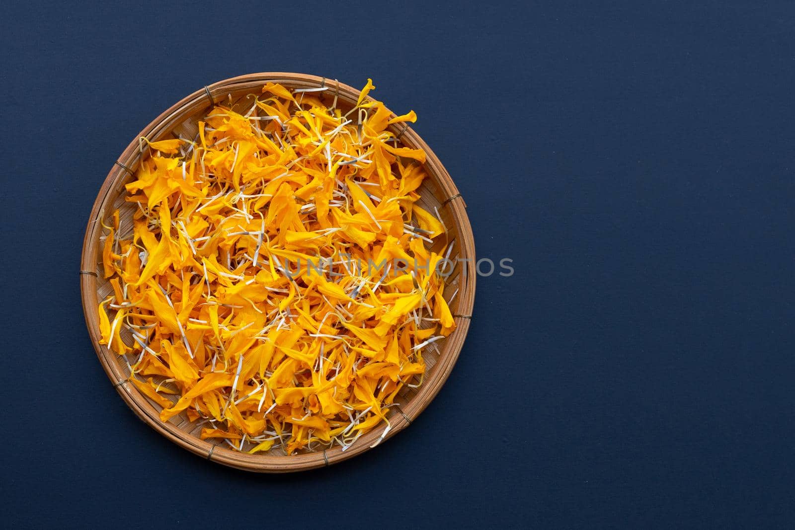 Petals of marigold flower on dark background.