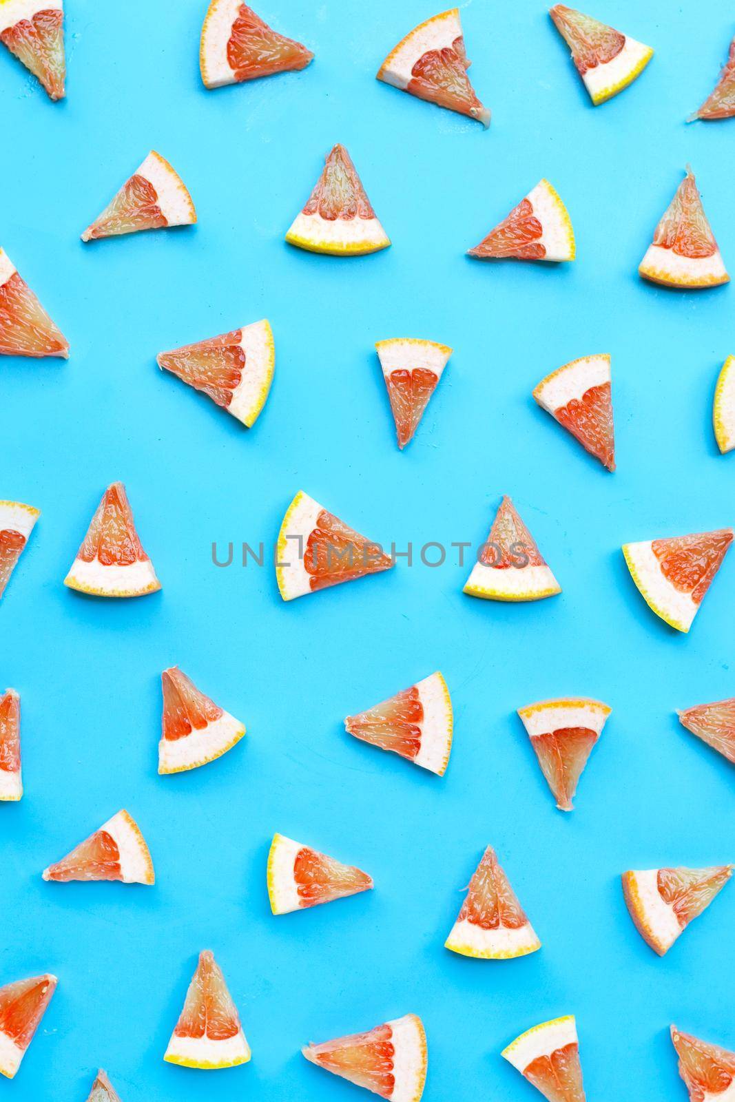 High vitamin C. Juicy grapefruit slices on blue background. by Bowonpat