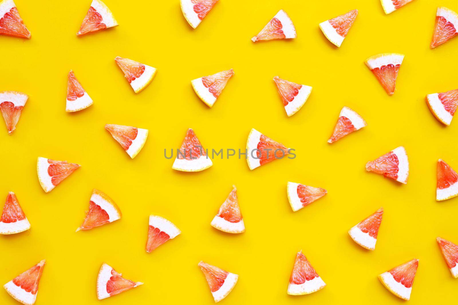High vitamin C. Juicy grapefruit slices on yellow background.