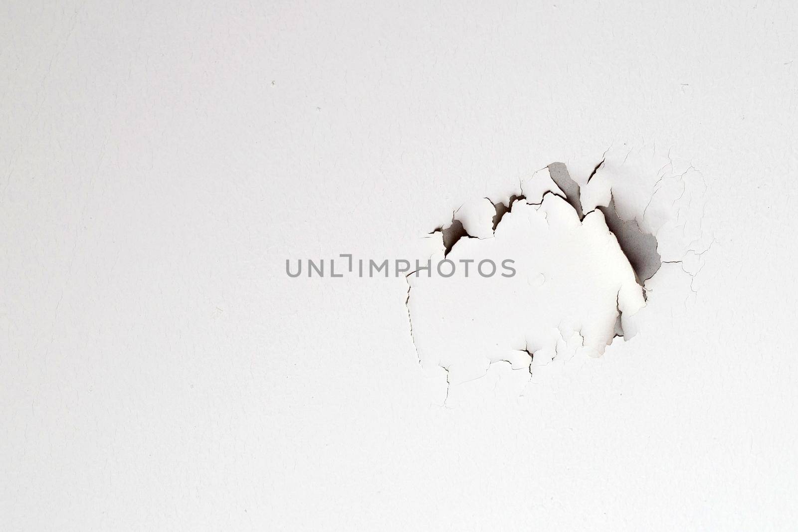 White color paint peeling off on ceiling house. Under the roof