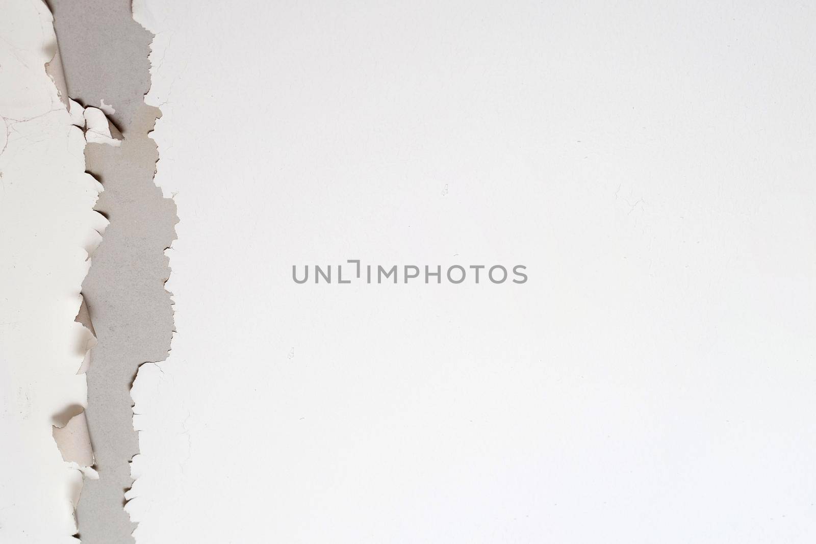 White color paint peeling off on ceiling house. Under the roof