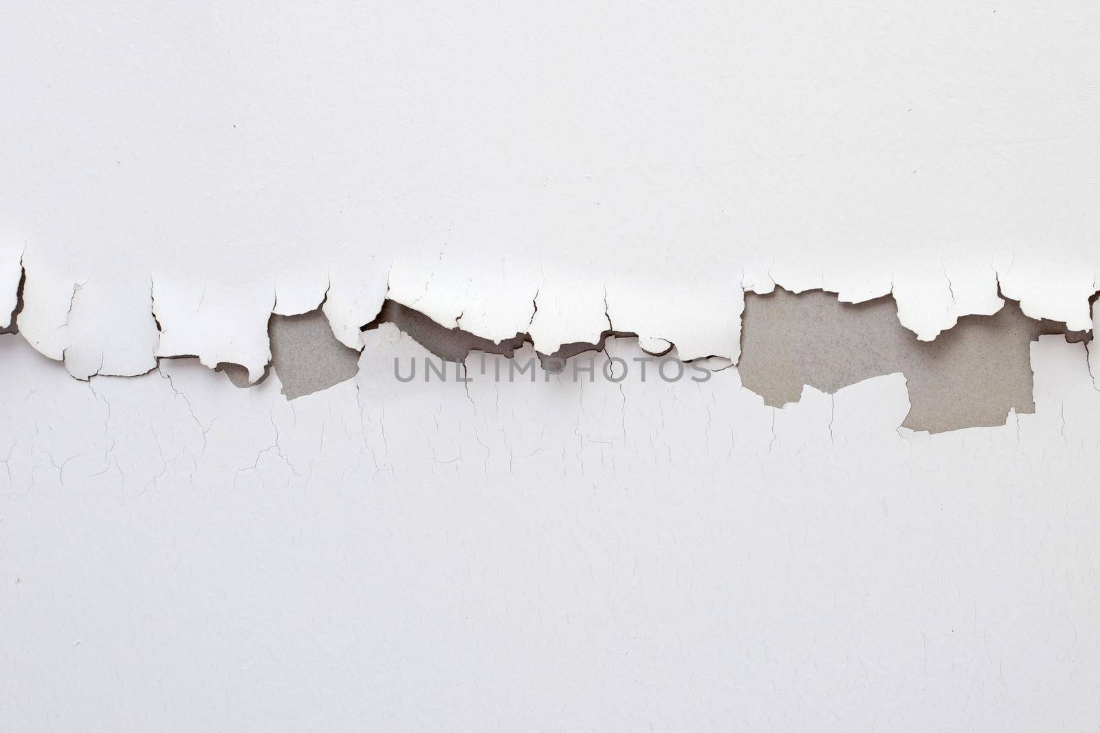 White color paint peeling off on ceiling house. Under the roof
