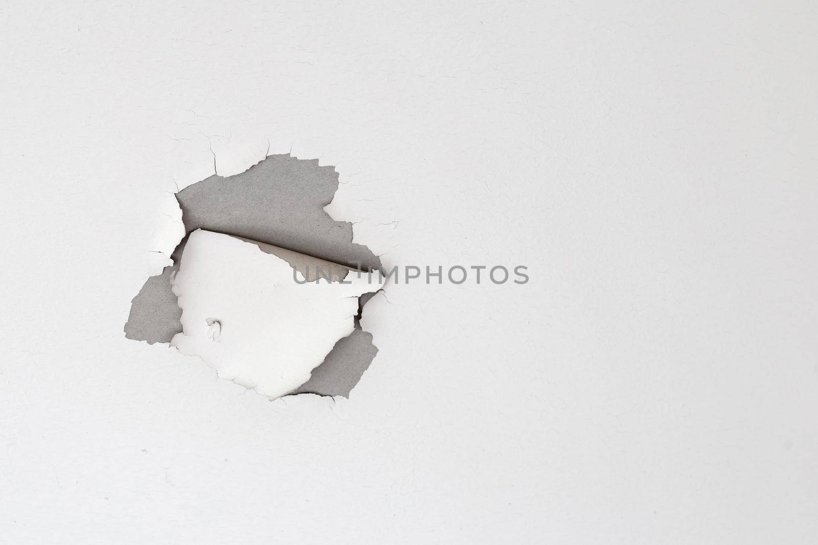 White color paint peeling off on ceiling house. Under the roof