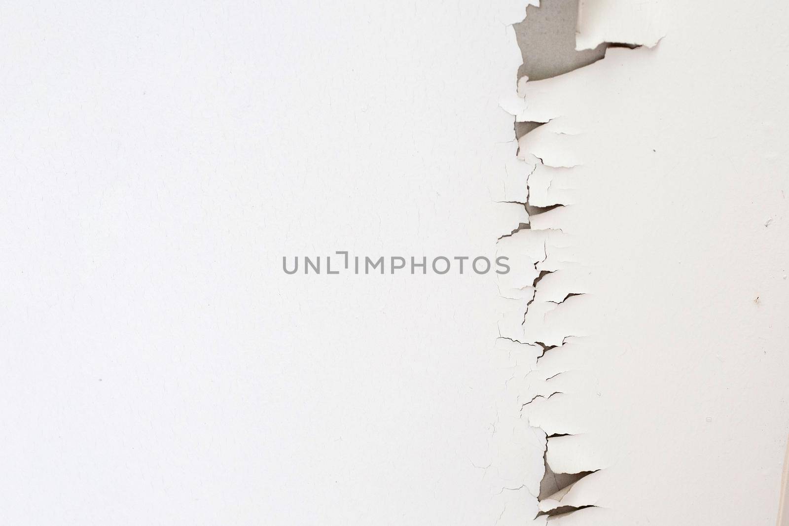 White color paint peeling off on ceiling house. Under the roof