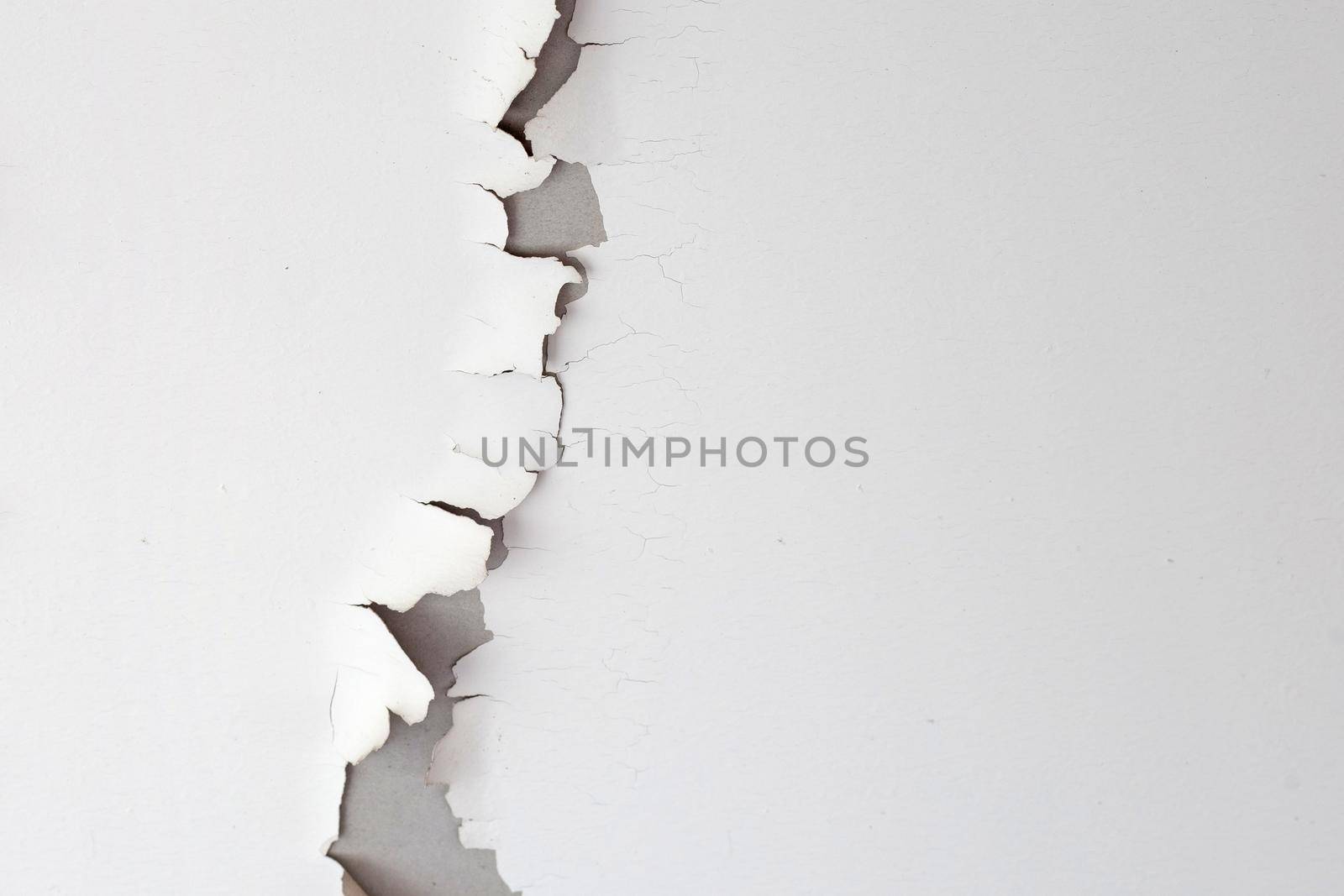 White color paint peeling off on ceiling house. Under the roof