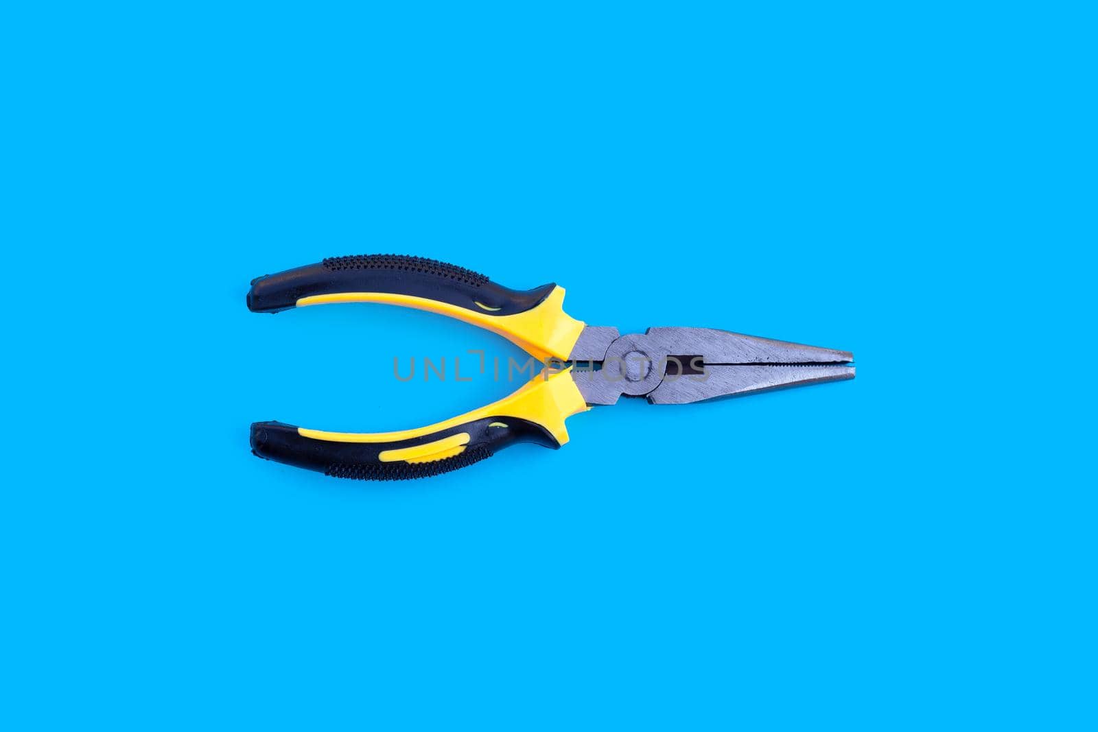 Yellow pliers on blue background.