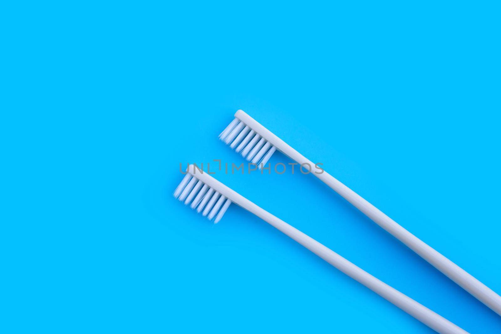 Toothbrushes on blue background. Top view by Bowonpat