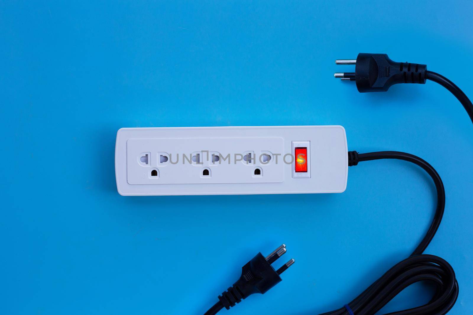 Electrical power strip and plug on blue background. Top view