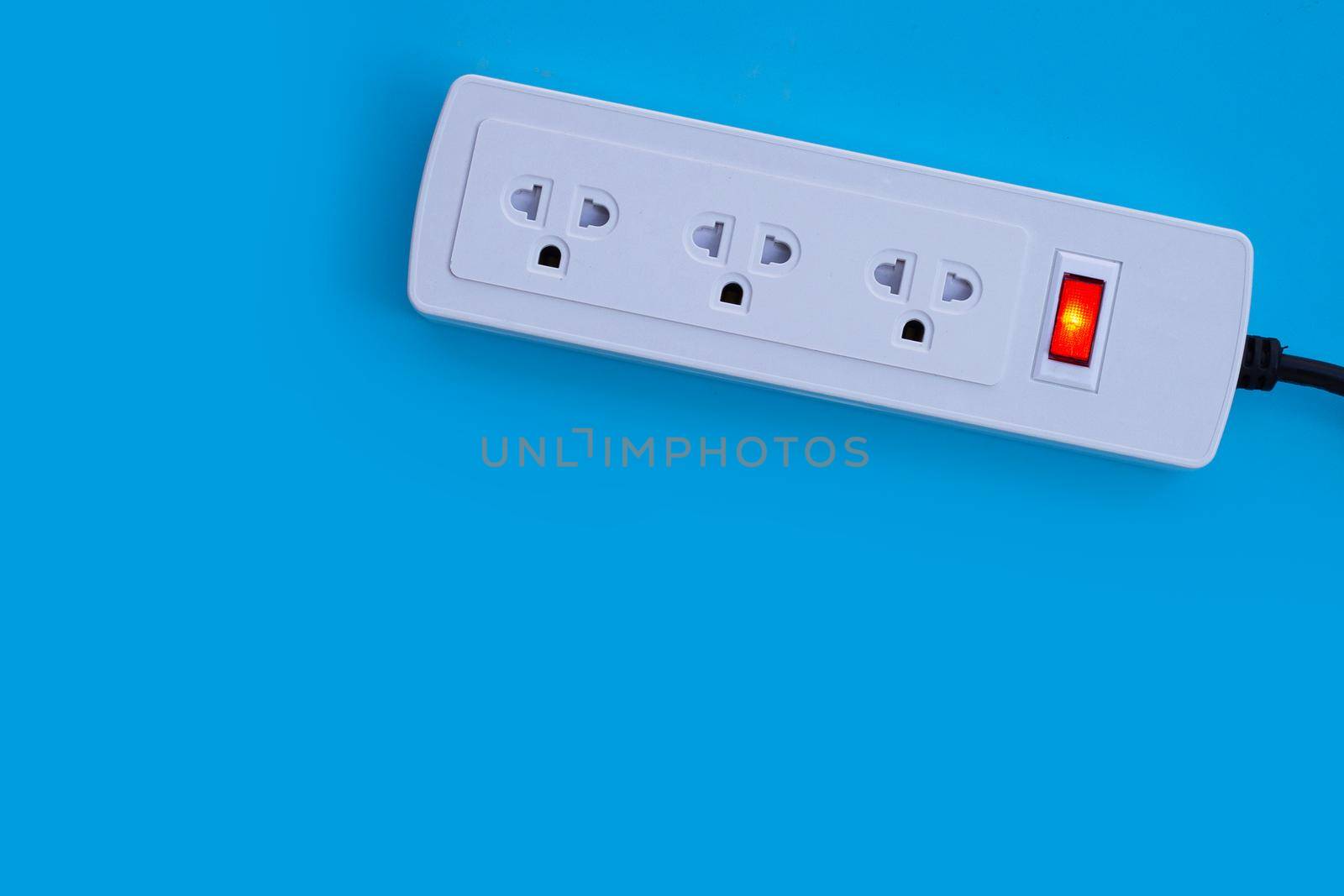 Electrical power strip on blue background. Top view