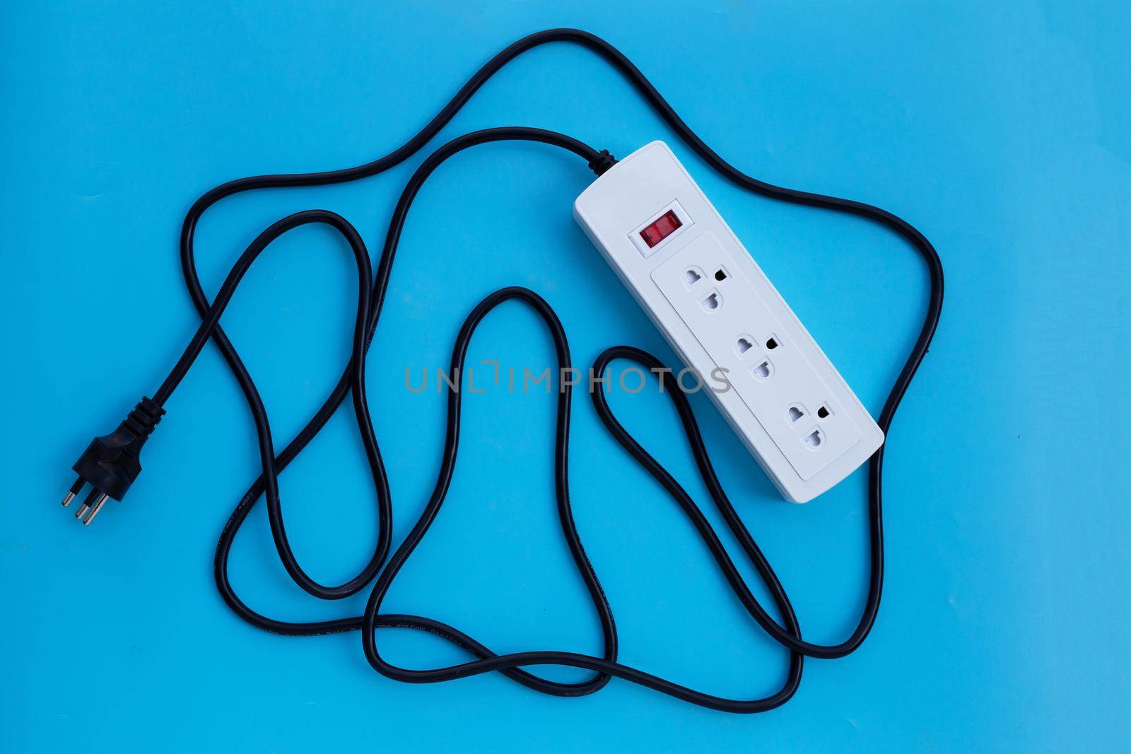 Electrical power strip and plug on blue background. Top view