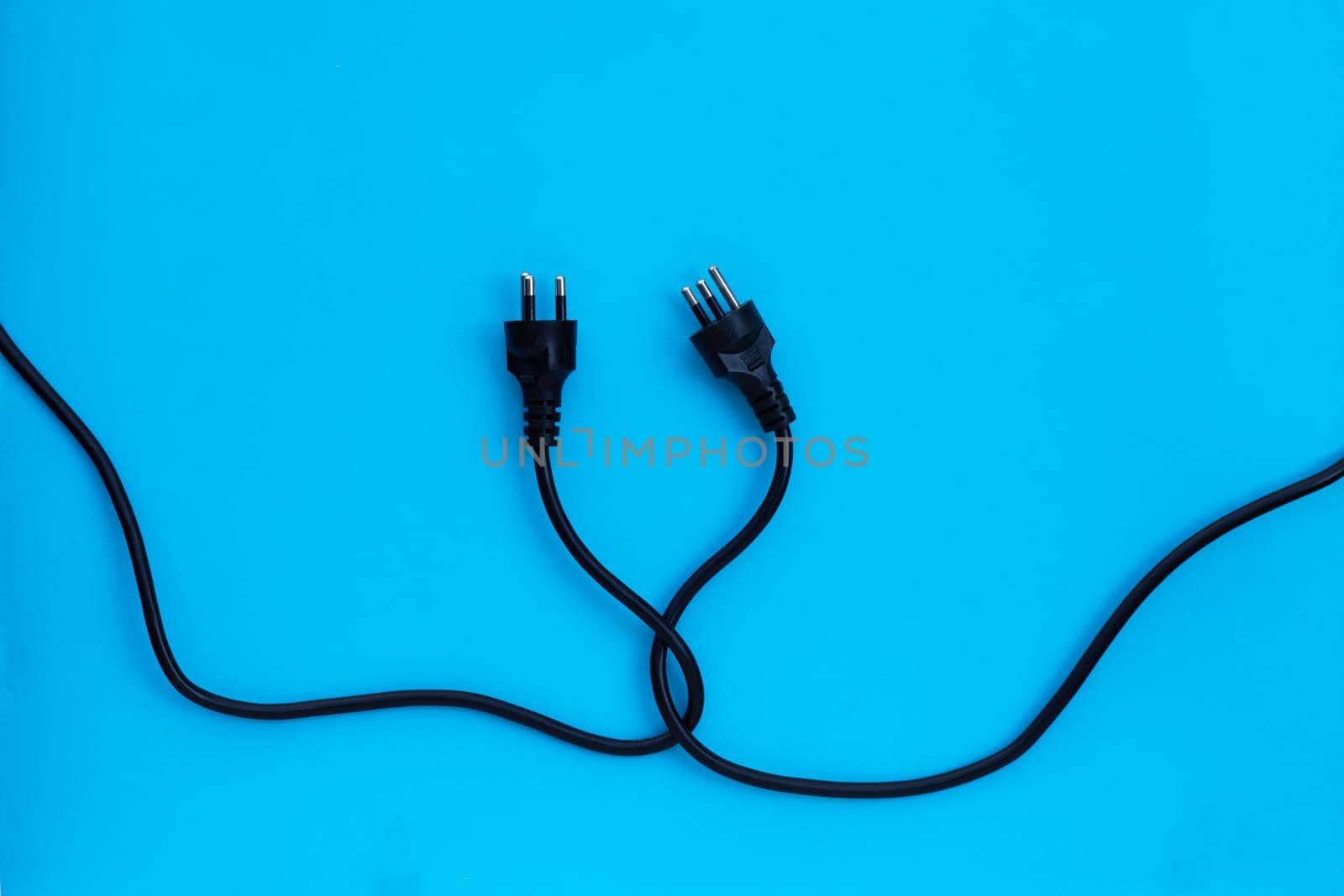 Electric plugs on blue background. Top view