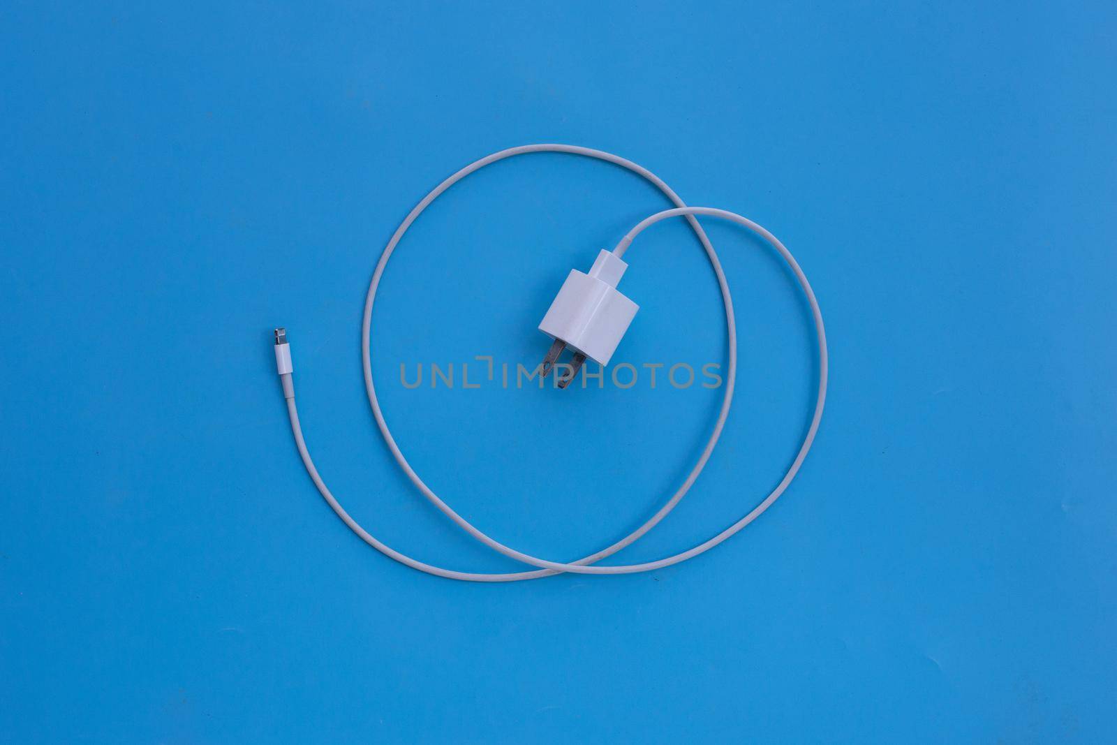 Mobile phone charger on blue background.