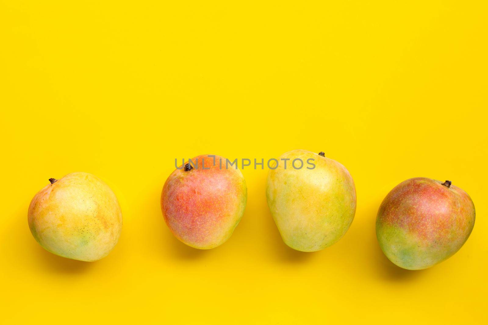 Tropical fruit, Mango on yellow background. Copy space