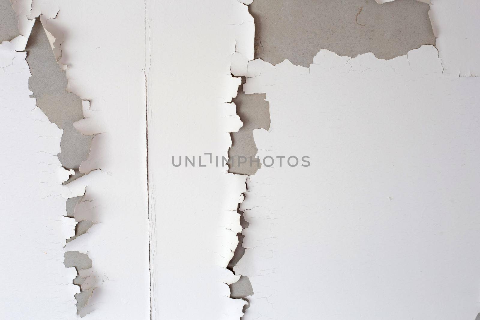White color paint peeling off on ceiling house. Under the roof