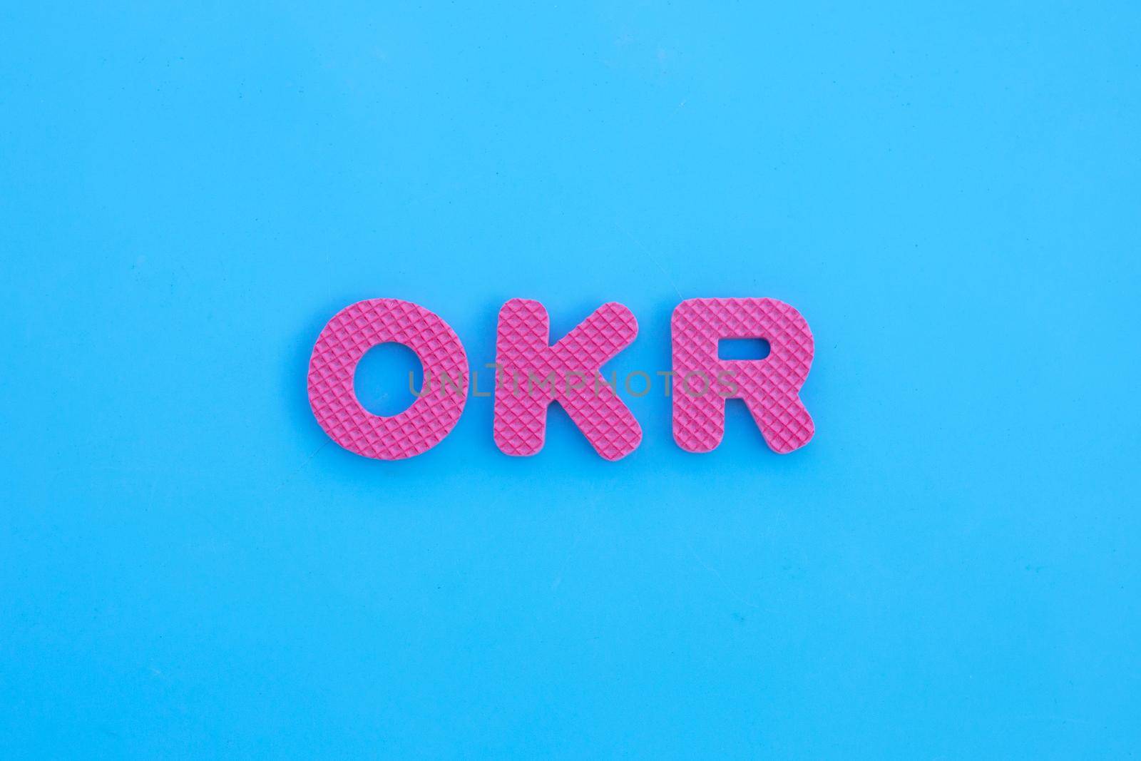 OKR alphabets on blue background.
