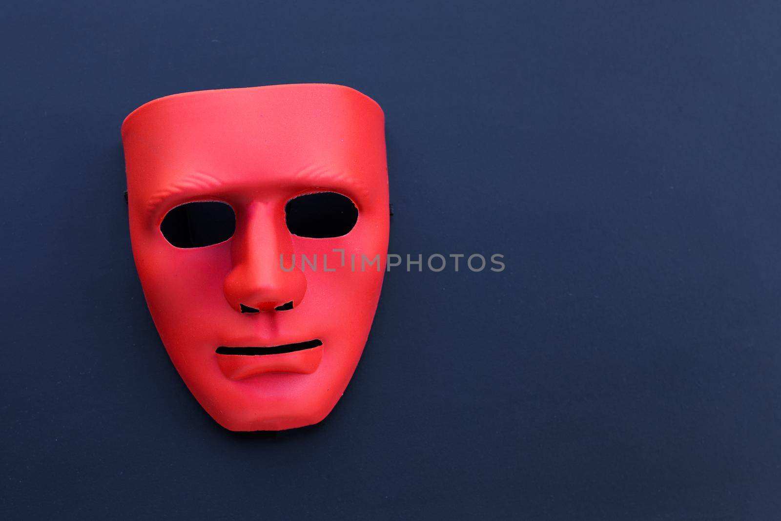 Red mask on the dark background. 