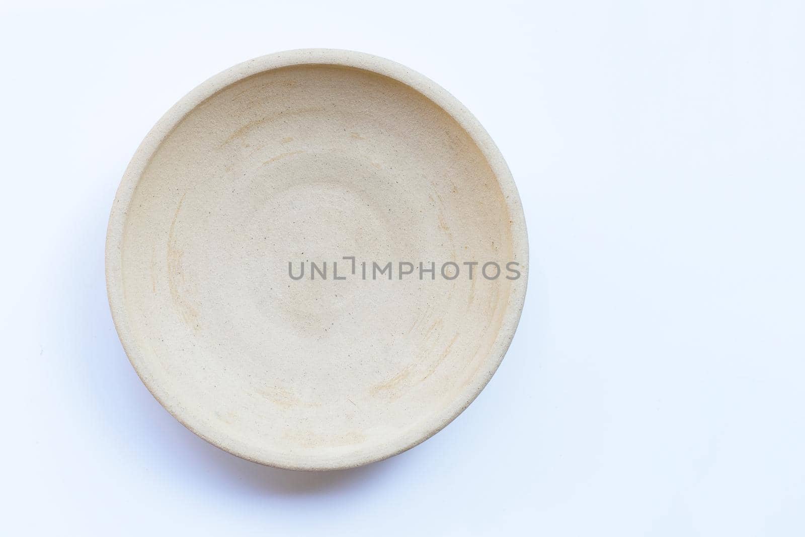 Empty pottery plate on white background. Copy space
