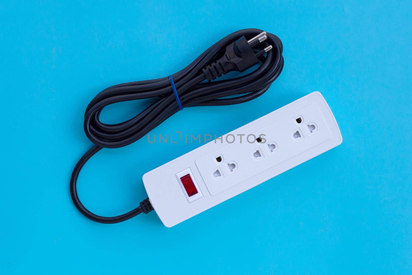 Electrical power strip and plug on blue background. Top view