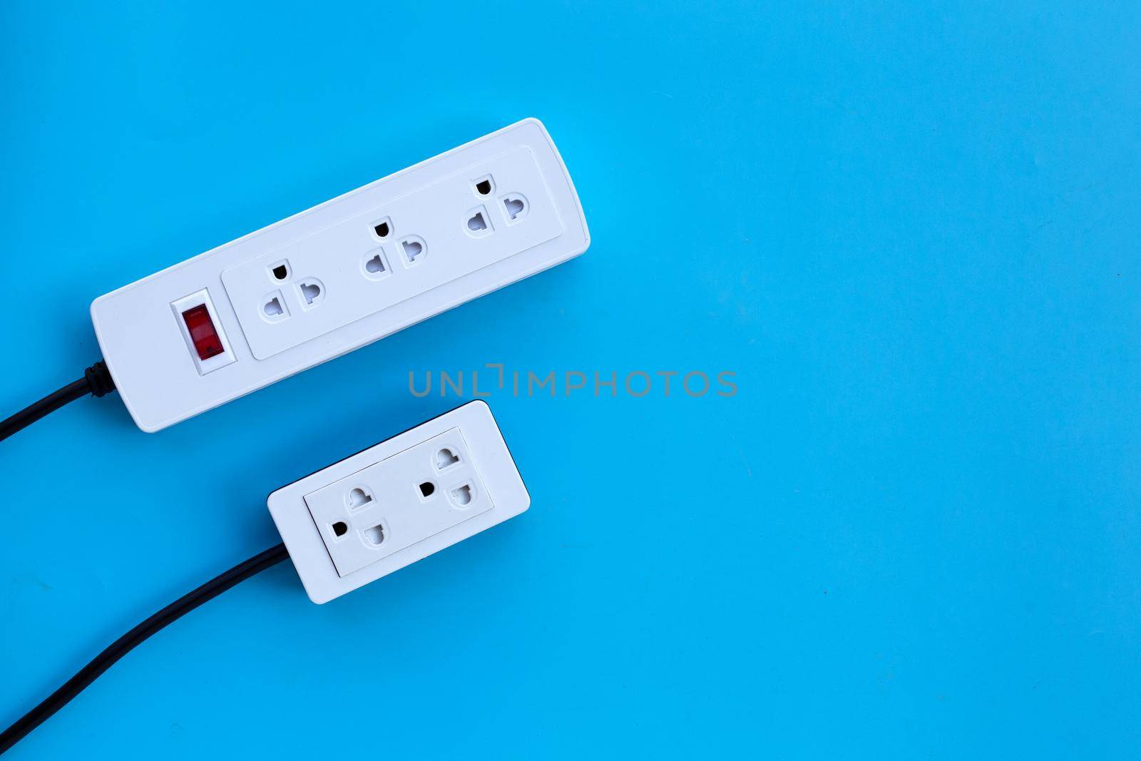 Two electrical power strip on blue background. Top view