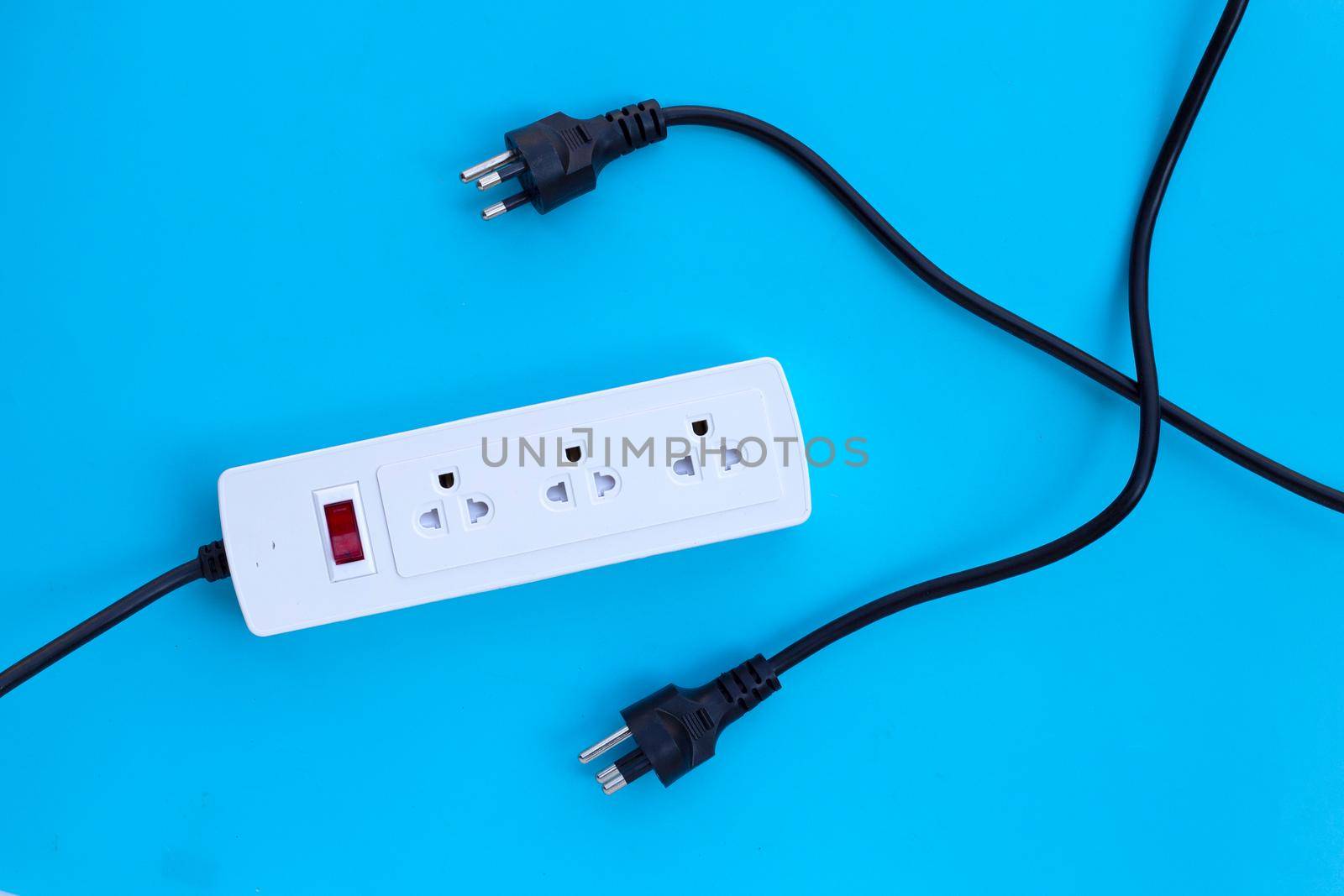 Electrical power strip and plugs on blue background. Top view