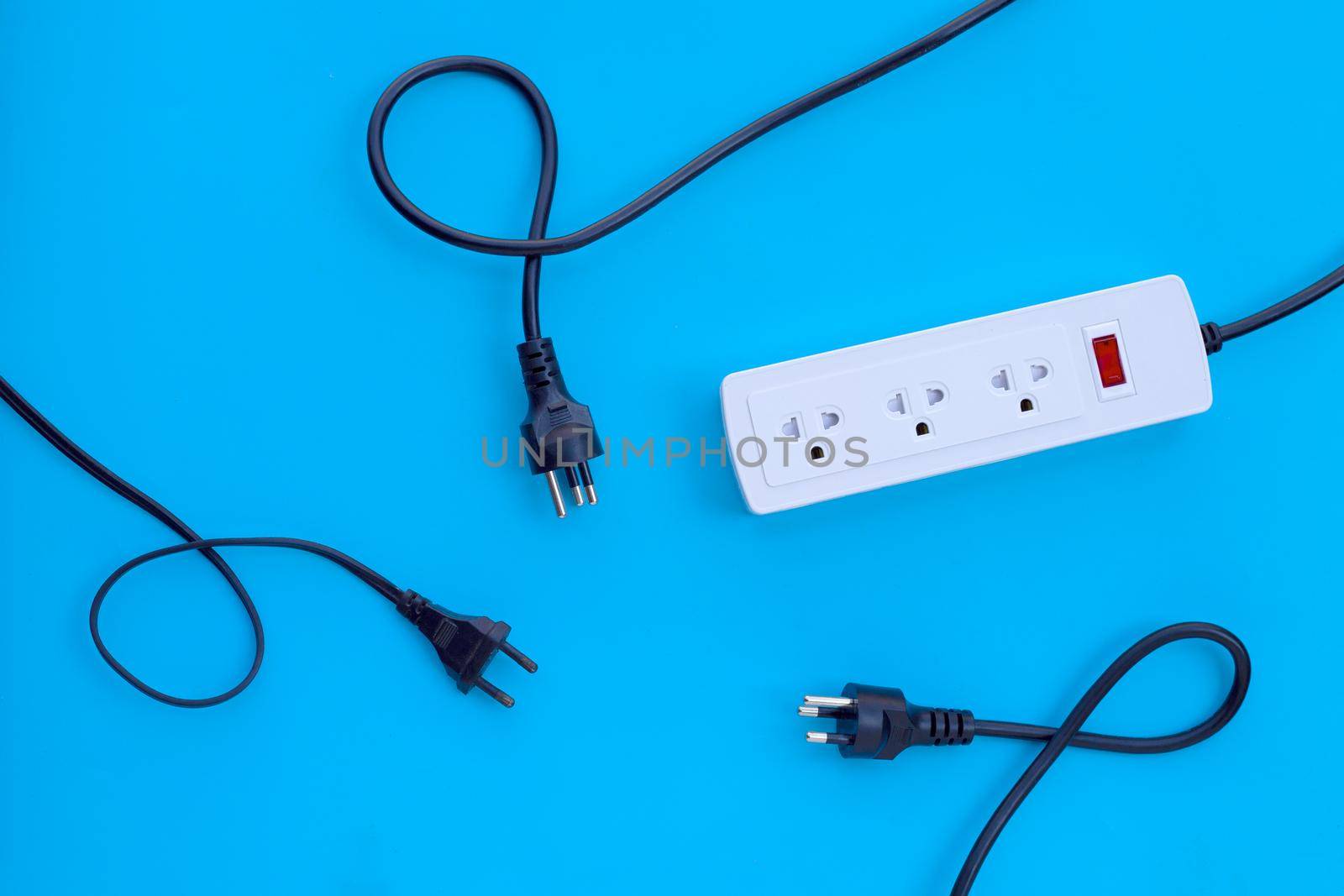 Electrical power strip and plug on blue background. Top view