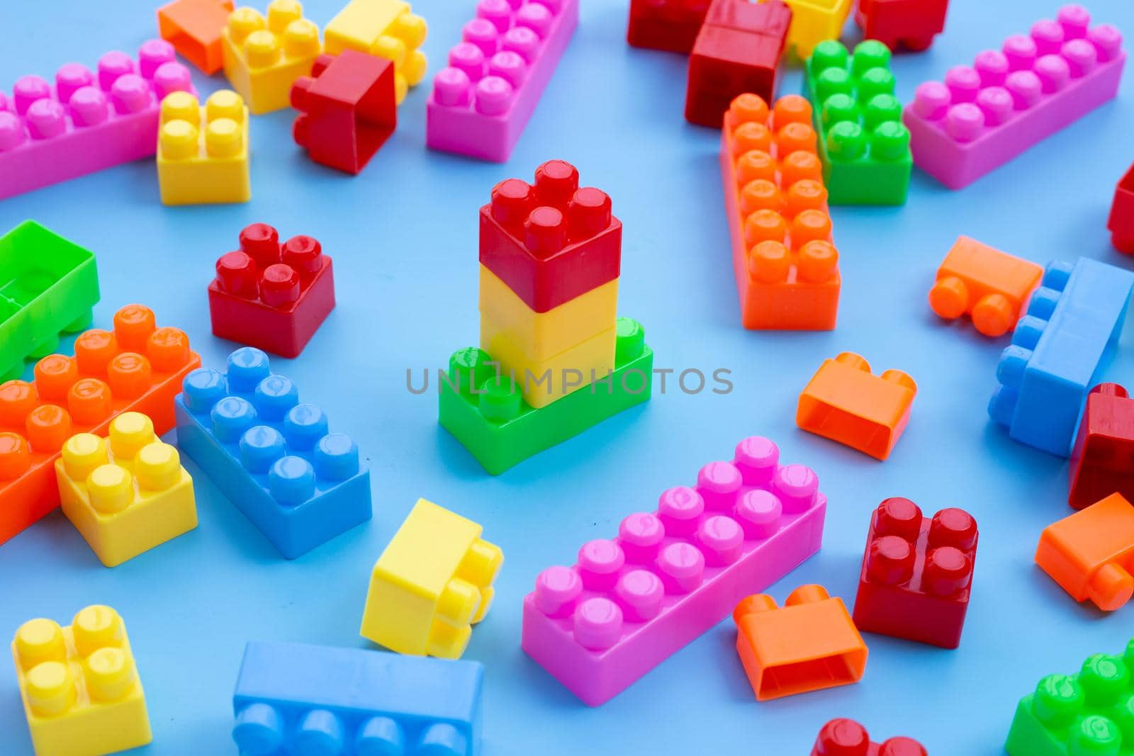 Plastic building blocks on blue background.