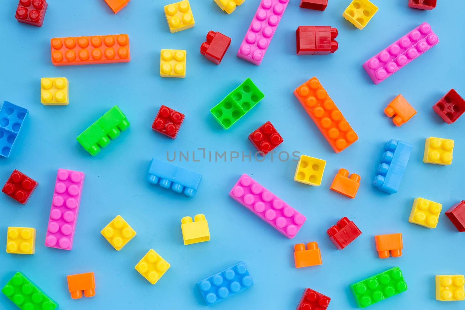Plastic building blocks on blue background.