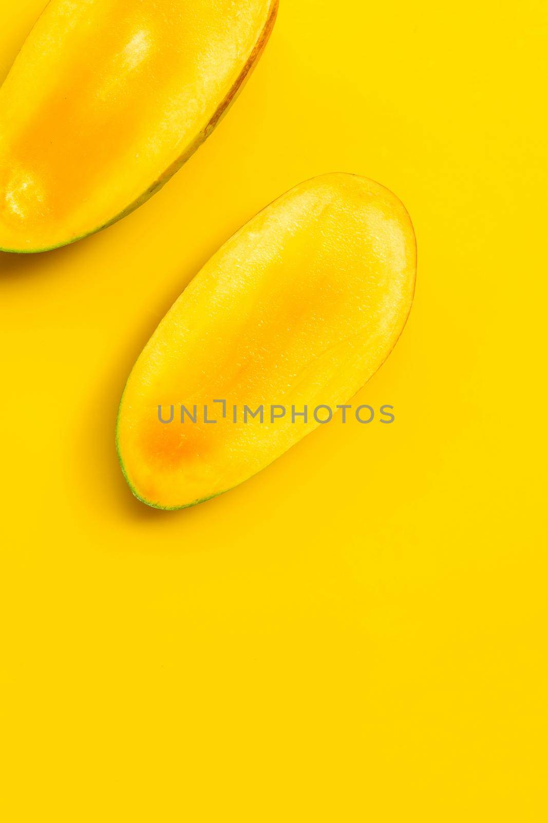 Mango on yellow background. Tropical sweet fruit concept. by Bowonpat