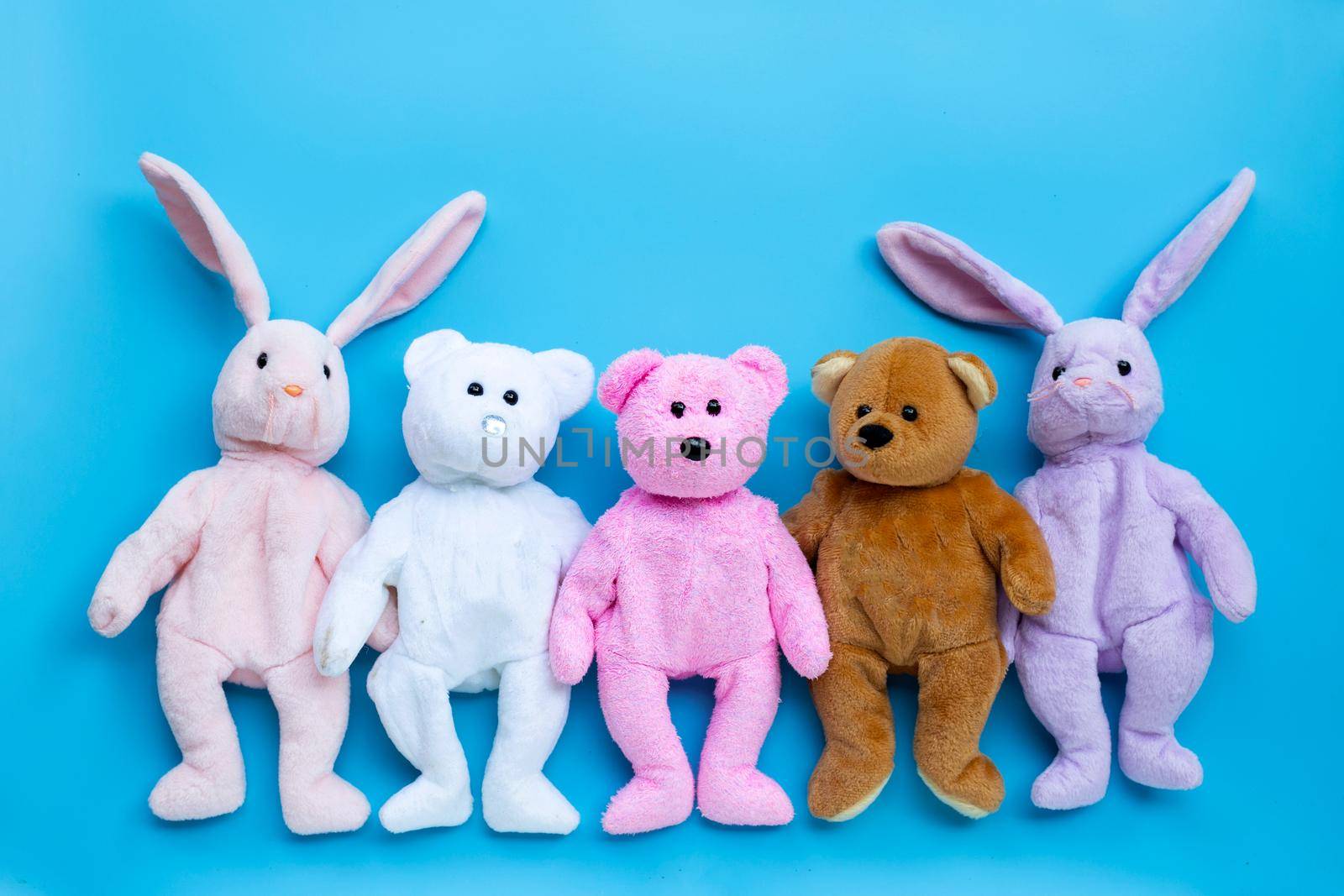 Toy rabbits and bears on blue background.