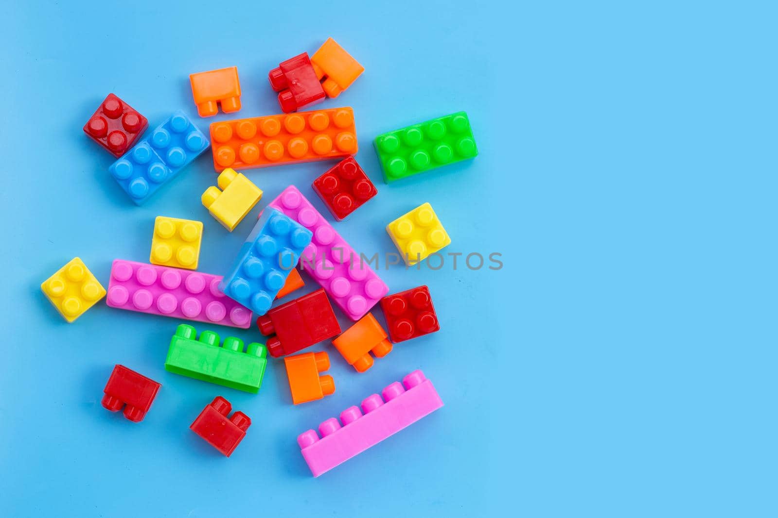 Plastic building blocks on blue background.