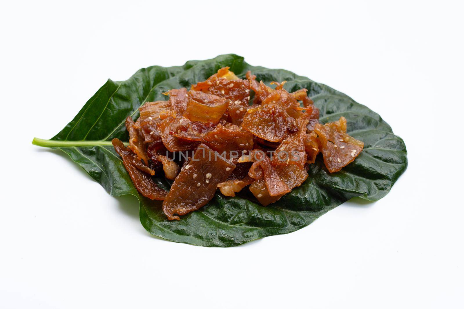 Sweet pork or pork Jerky on noni or morinda citrifolia leaf. white background.