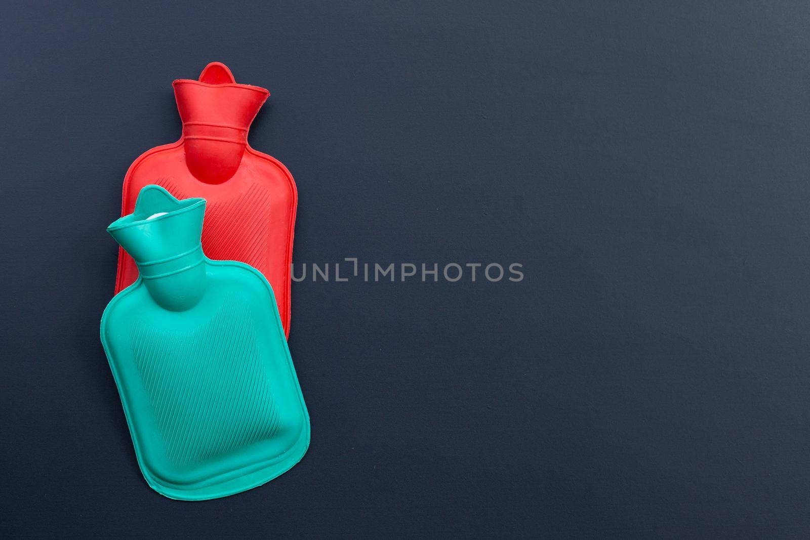 Hot water bags on dark background. Copy space