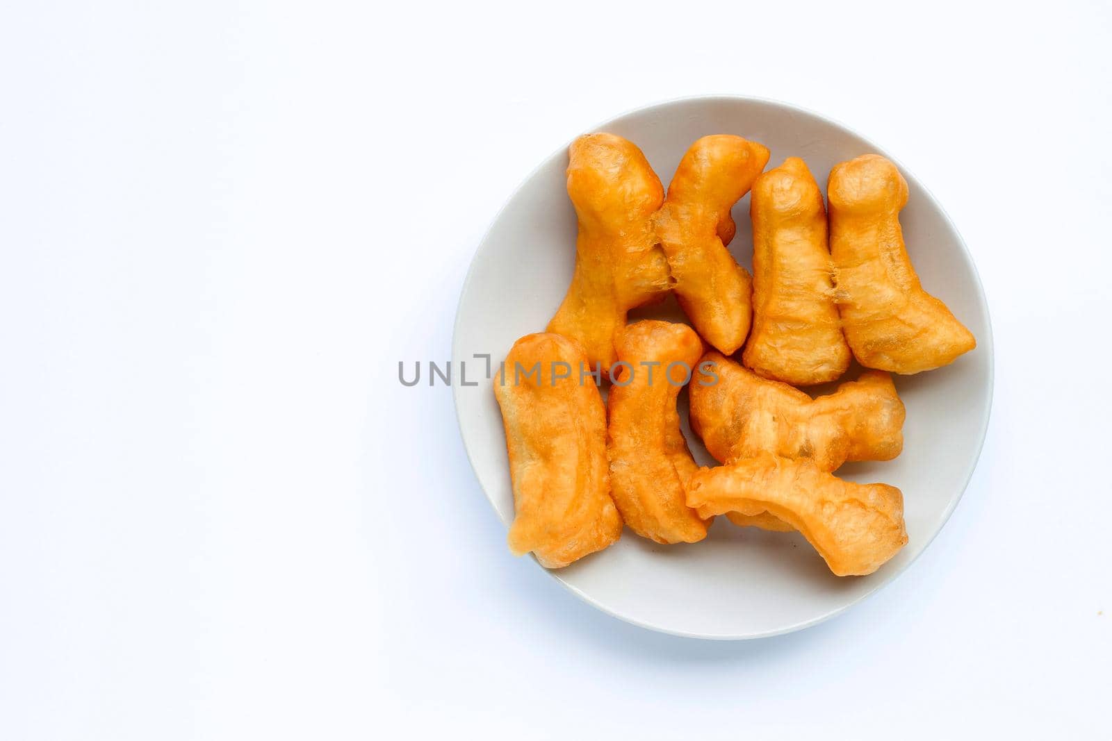 Deep-fried dough stick, chinese bread stick in white dish on white background with copy space