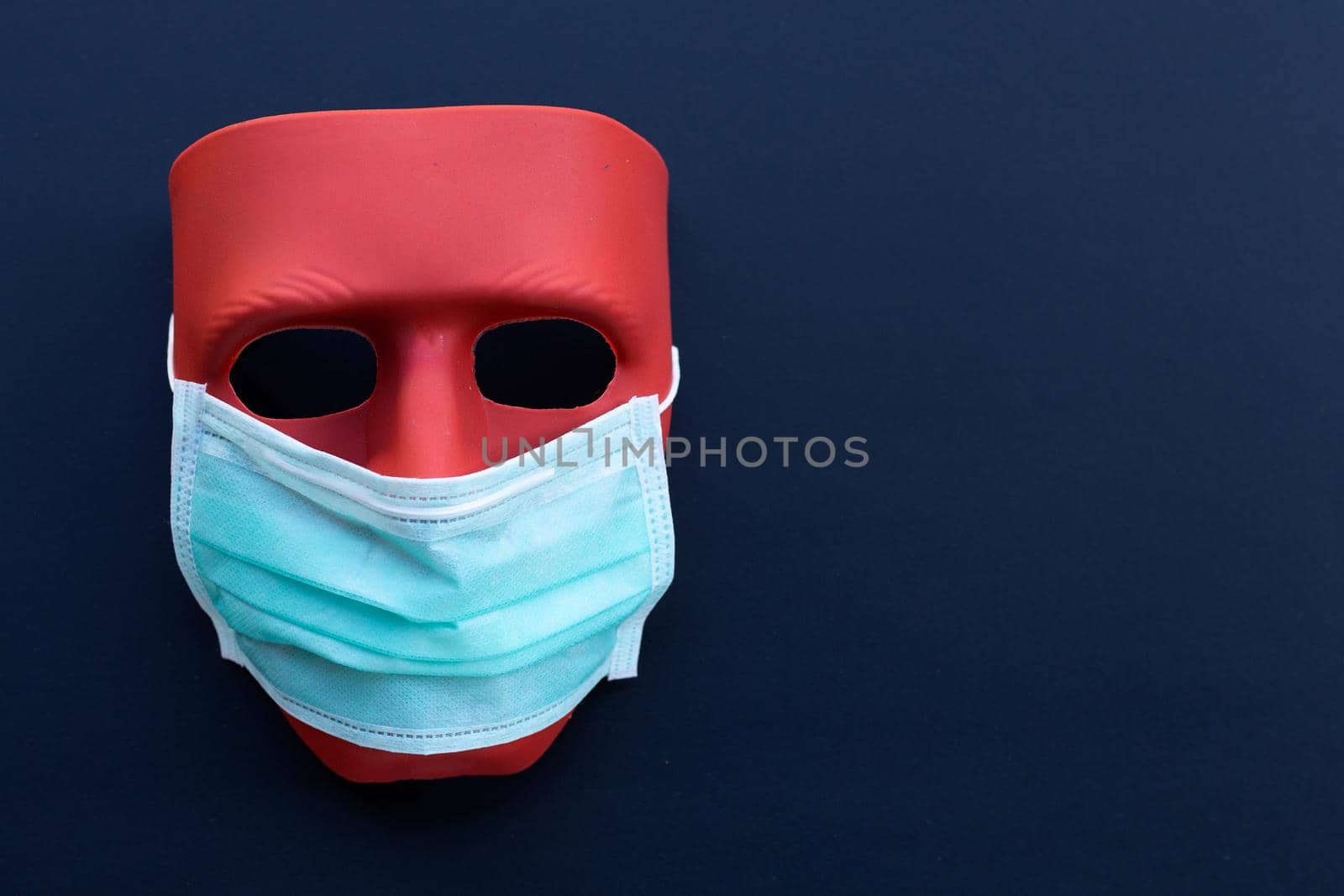 Red mask wear protective face mask on dark background. 