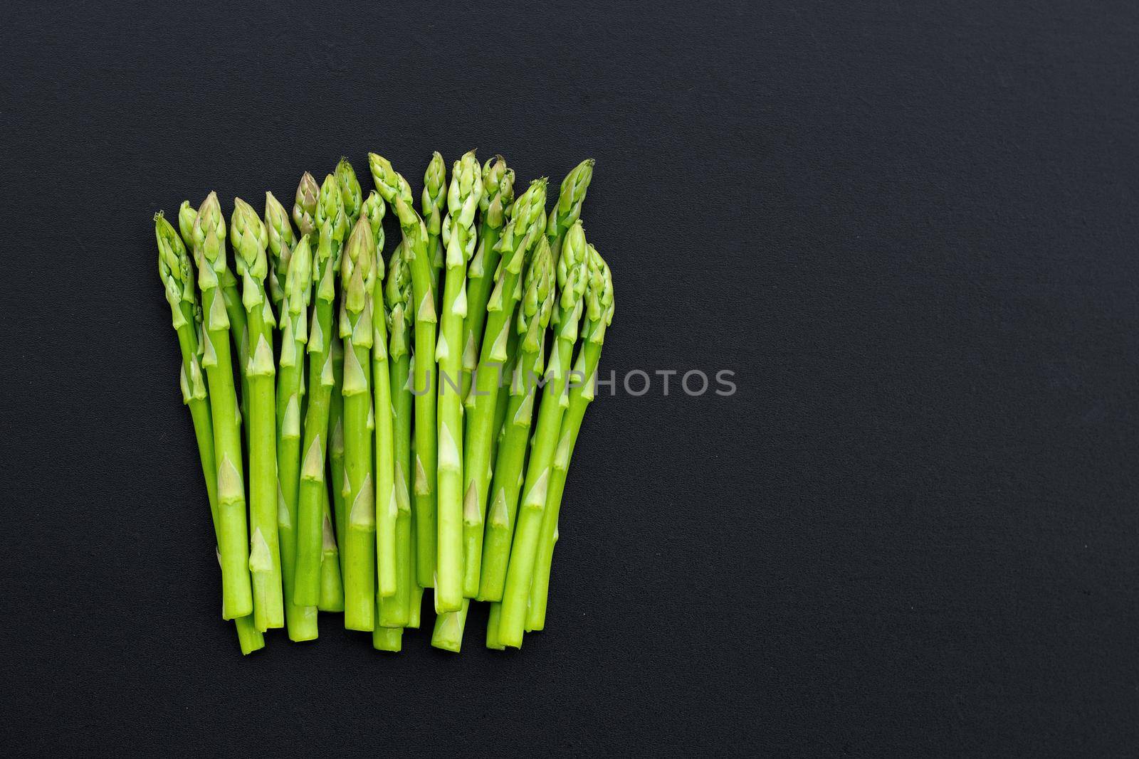 Fresh asparagus on dark background. Copy space