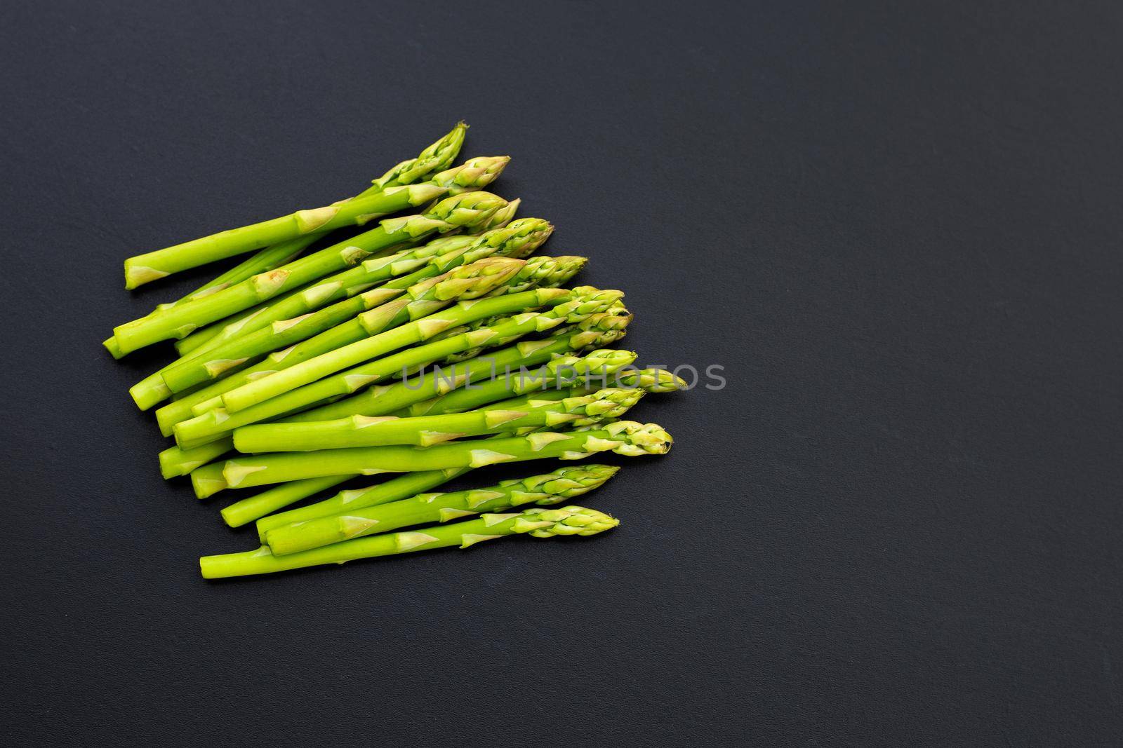 Fresh asparagus on dark background. Copy space