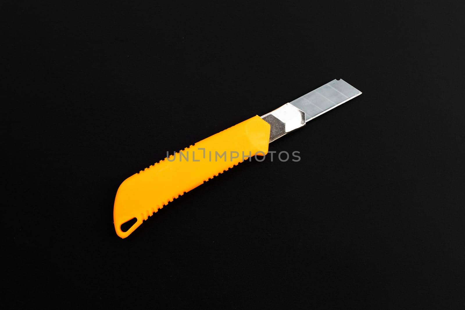 Stationery knife on dark background.
