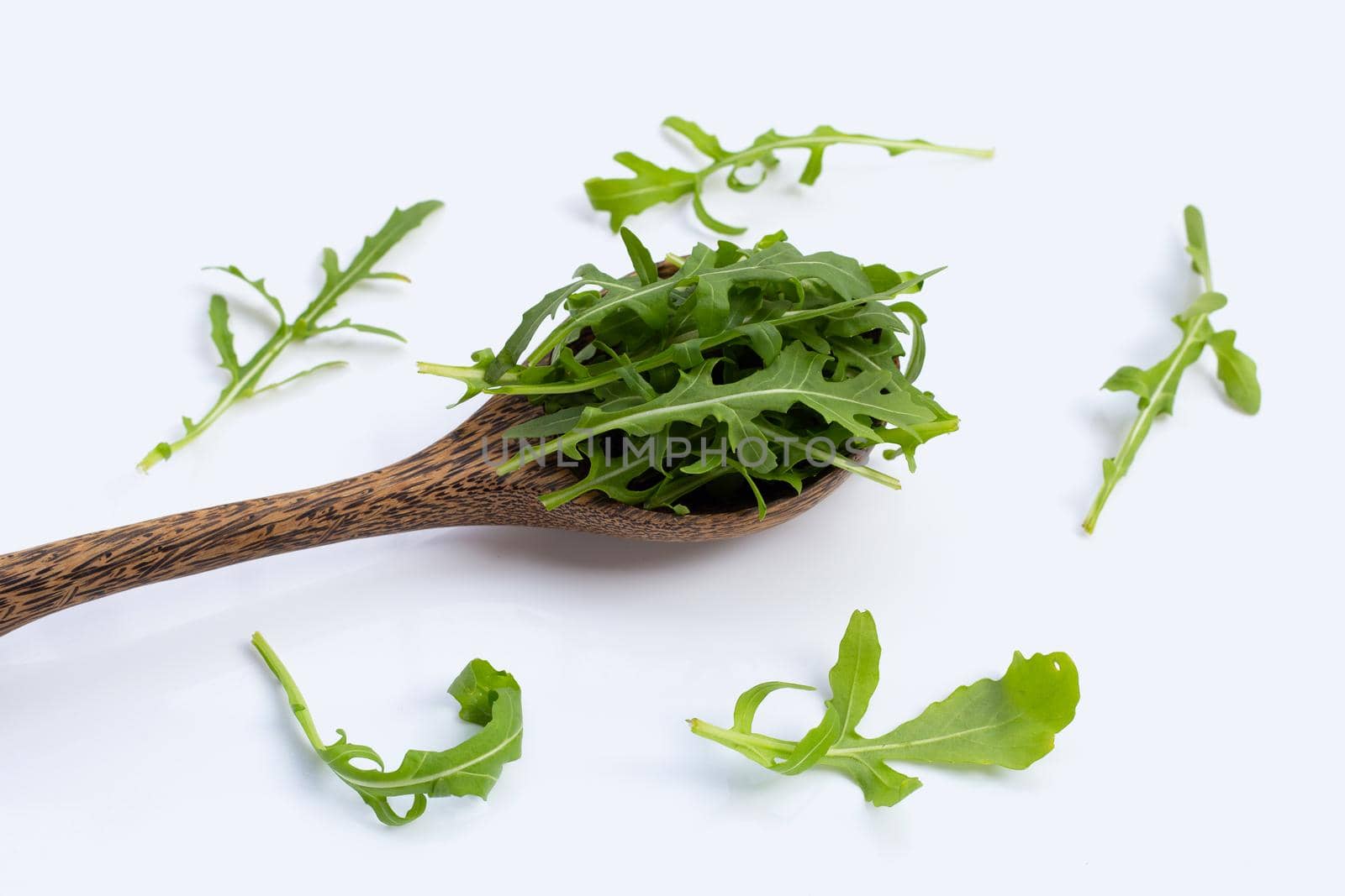 Fresh green rocket salad on white background.