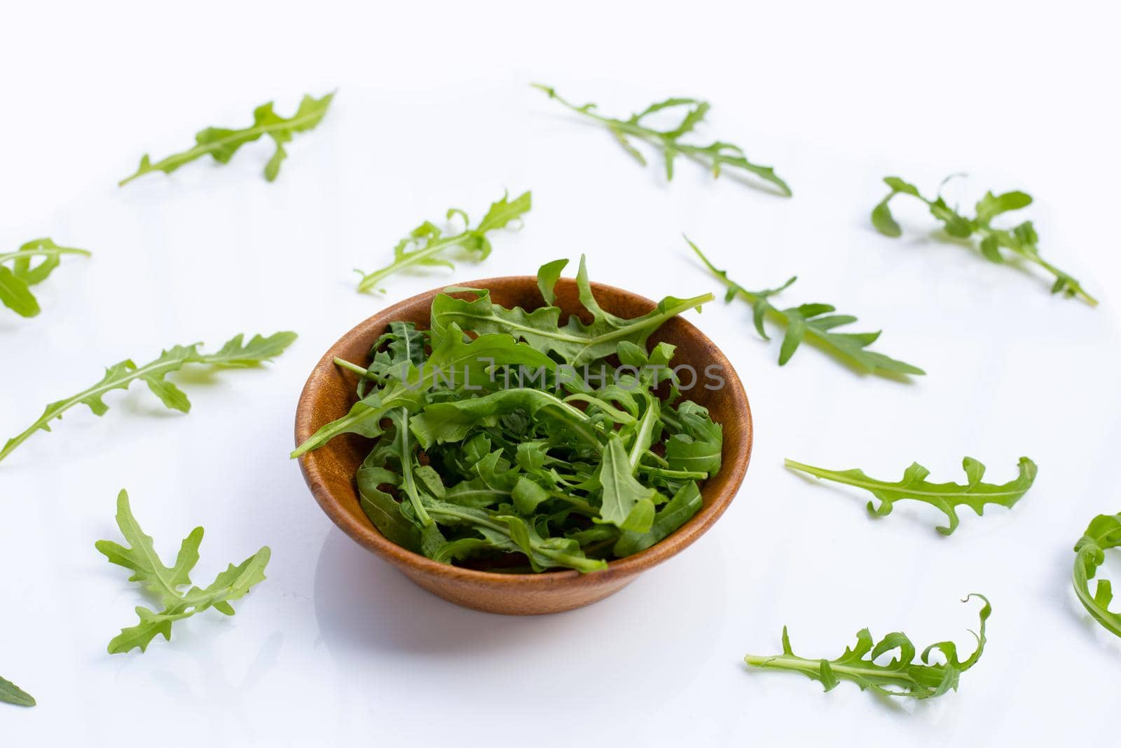 Fresh green rocket salad on white background.