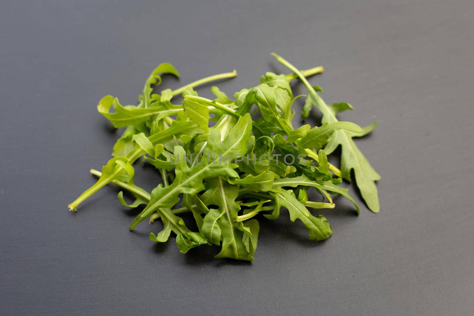 Fresh green rocket salad on dark background.