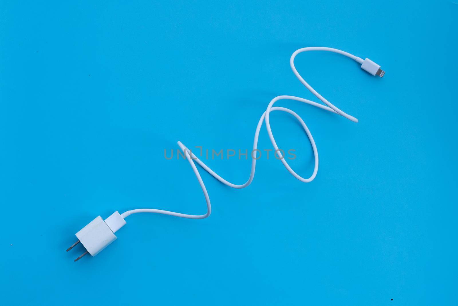 Mobile phone charger on blue background.