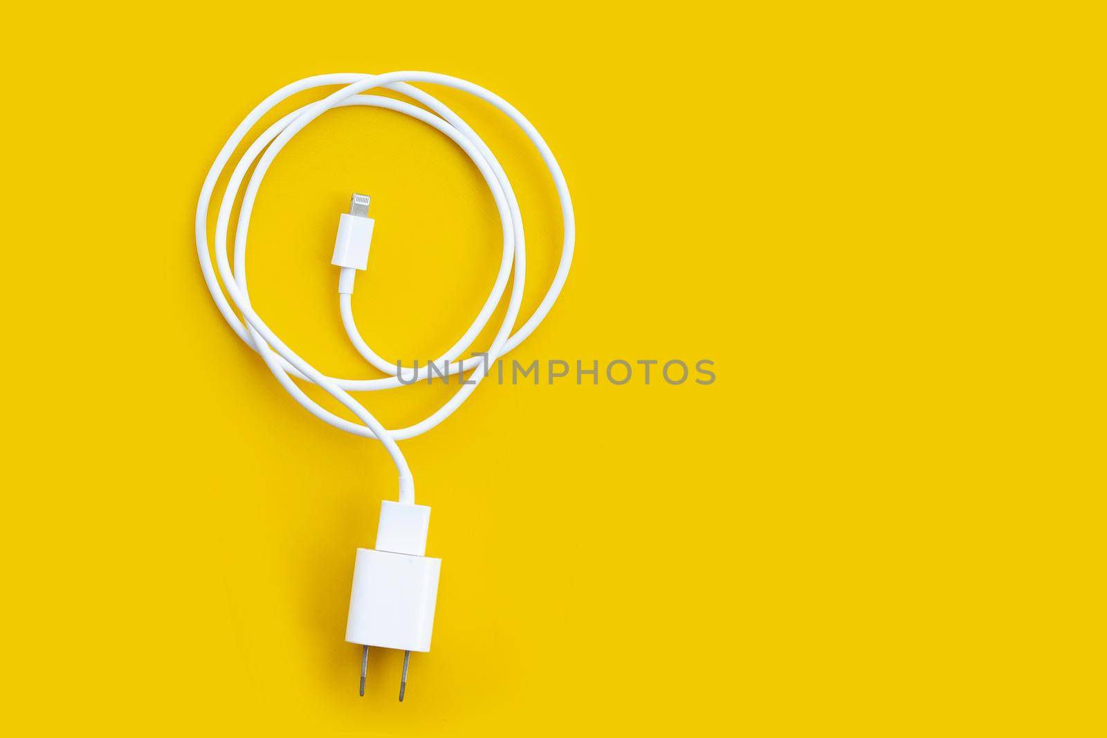 Mobile phone charger on yellow background.