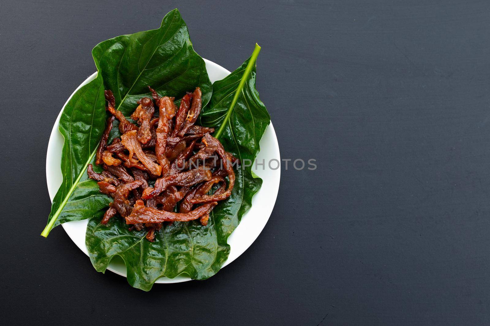 Deep fried sun-dried pork on dark background. Top view