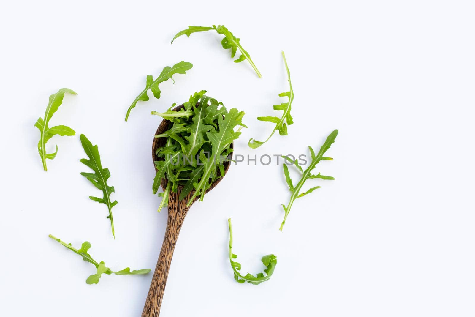 Fresh green rocket salad on white background.