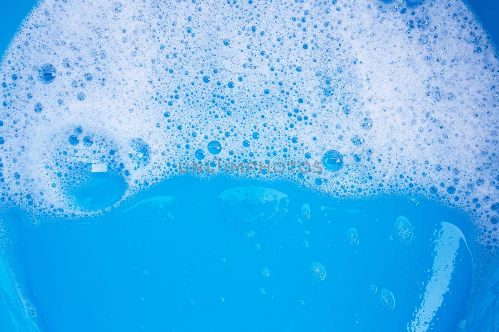 Detergent foam bubble on blue background. Top view