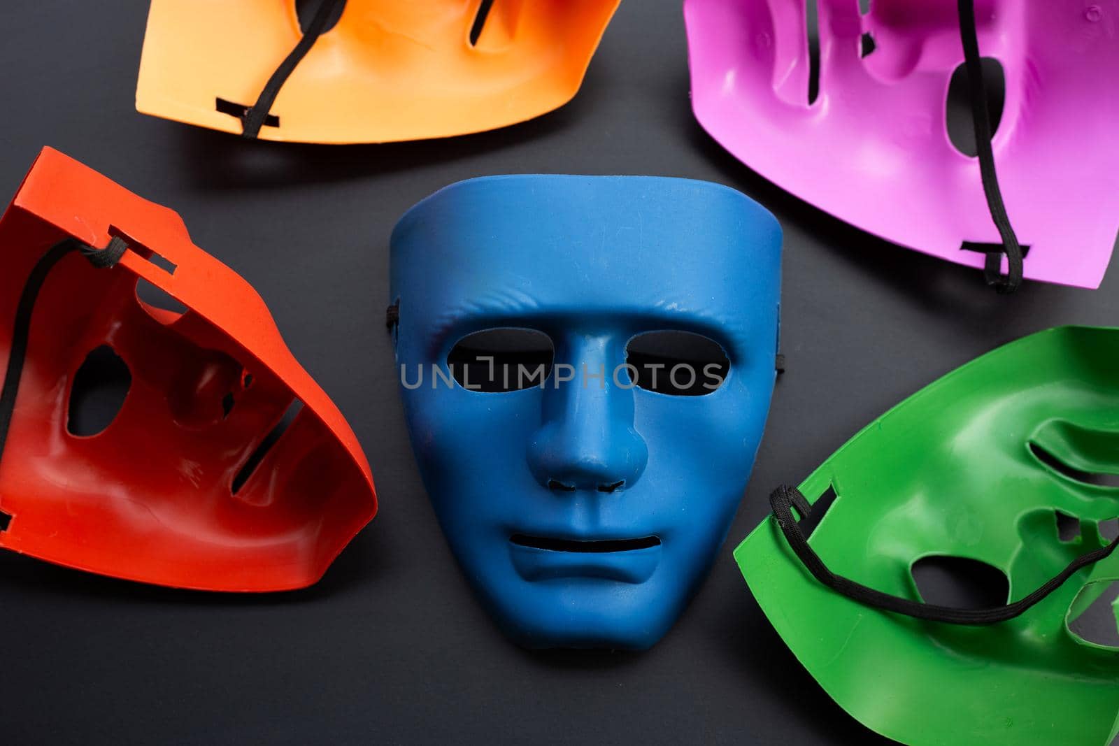 Five face masks on dark background.
