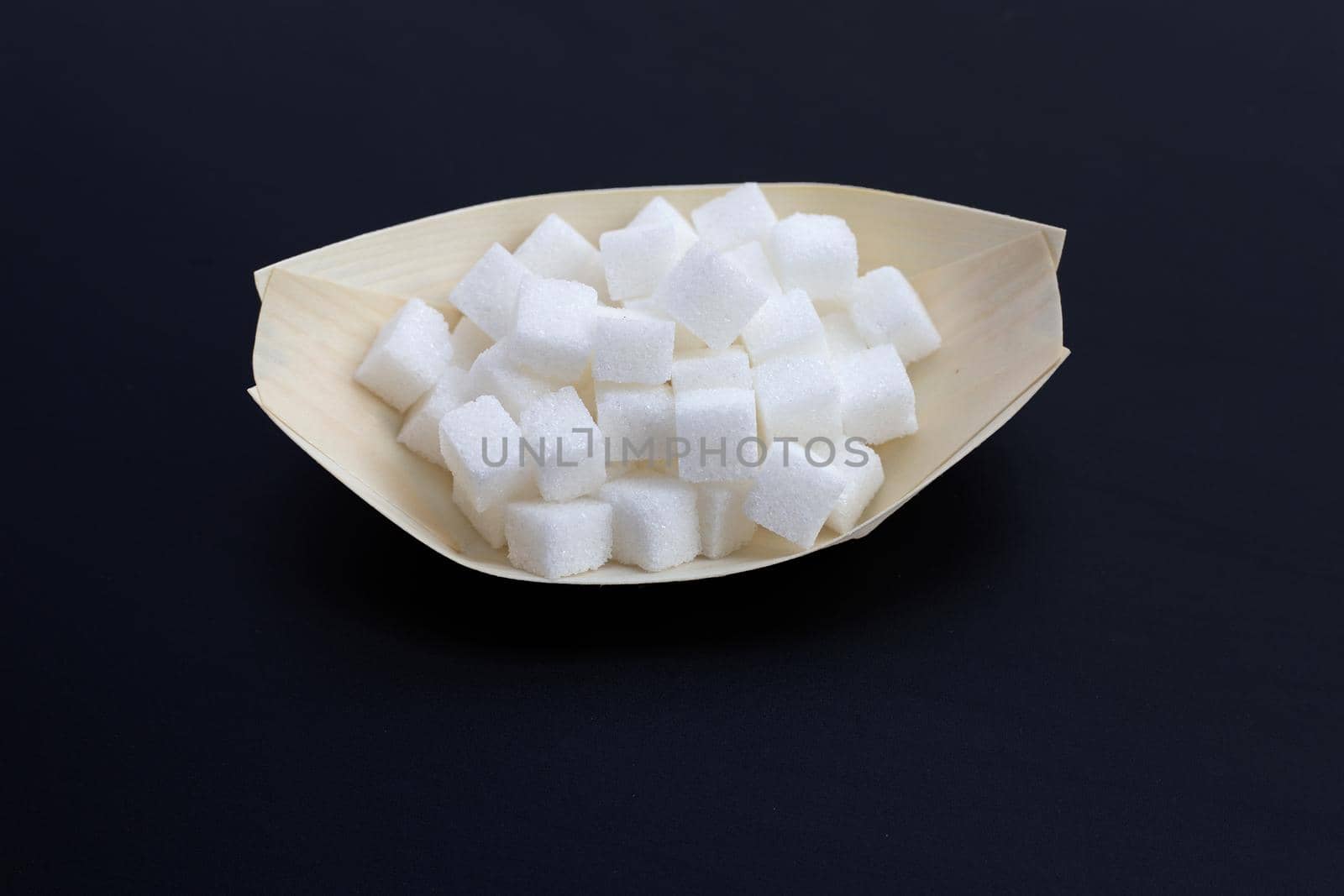 Cubes of sugar on dark background. Copy space