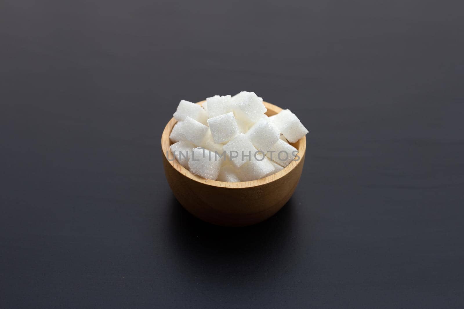 Cubes of sugar on dark background. Copy space
